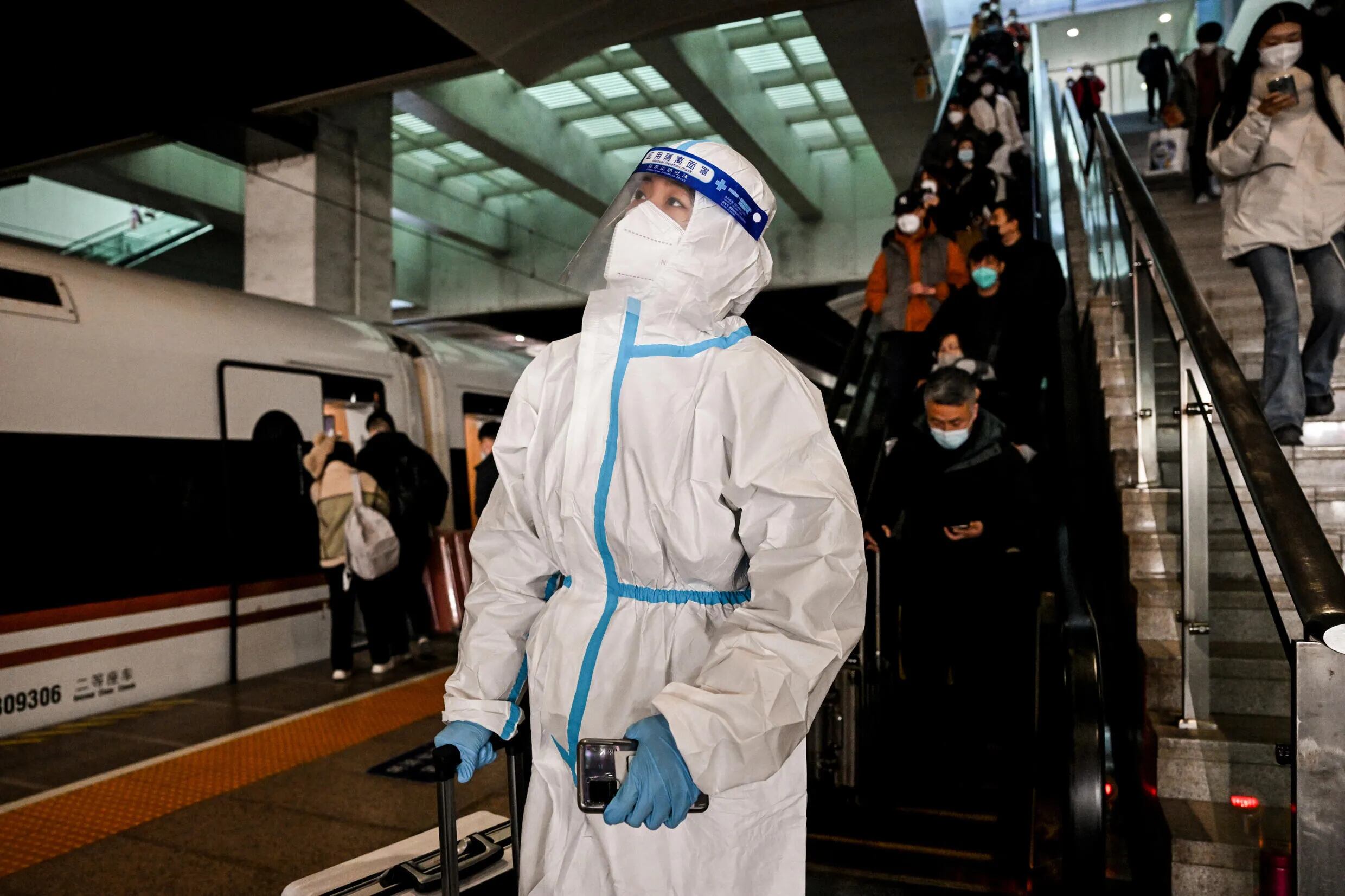 Un pasajero viste ropa protectora en una estación de tren de Pekín, el 28 de diciembre de 2022