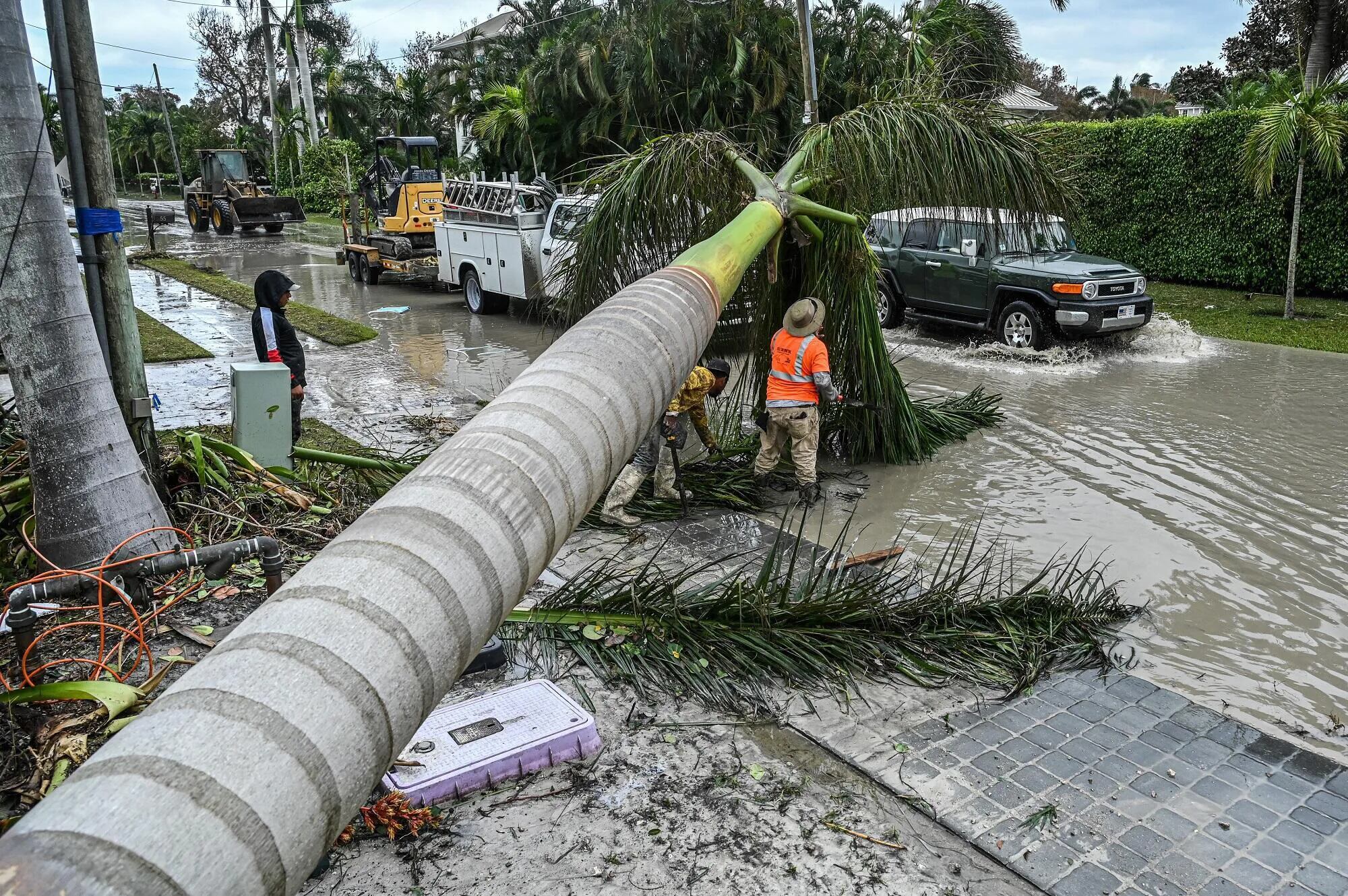 Trabajadores realizan la limpieza de escombros y árboles caídos tras el paso del huracán Ian en Naples, Florida, el 29 de septiembre de 2022.