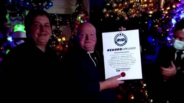10.000 bolas y 300 cables de luz: una pareja llenó su casa de arbolitos de Navidad y rompió un récord mundial