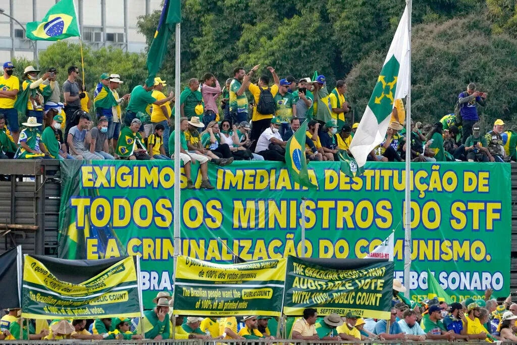 Simpatizantes del presidente de Brasil, Jair Bolsonaro, mostrando una pancarta que dice en portugués "Exigimos la destitución inmediata de todos los ministros de la Corte Suprema y la criminalización del comunismo", durante una manifestación, en Brasilia, Brasil, el miércoles 8 de septiembre de 2021.