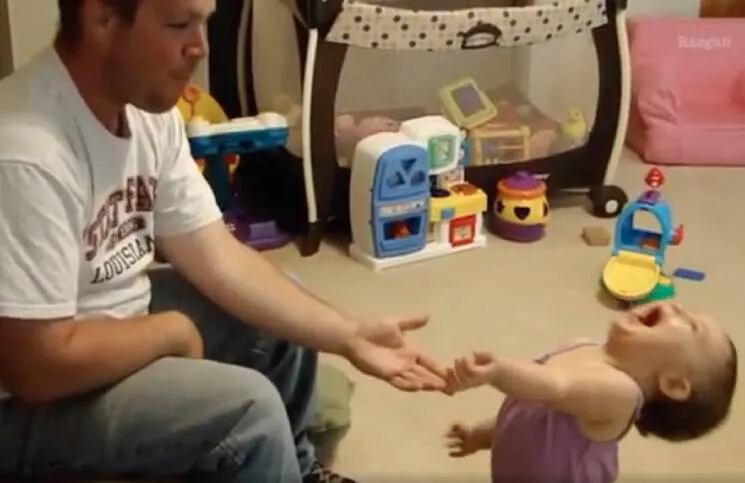 La reacción de una bebé al ver un truco de magia de su papá.